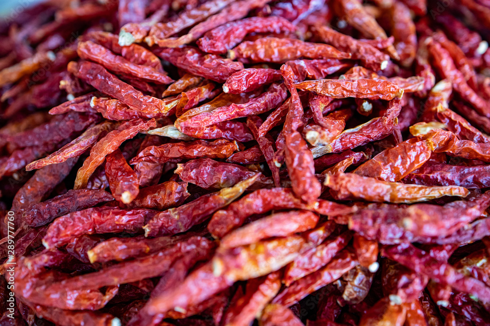 A group of dried Thai chili peppers without stalks sold in the market as food ingredient for cooking A group of dried Thai chili peppers without stalks sold in the market as food ingredient for cooking