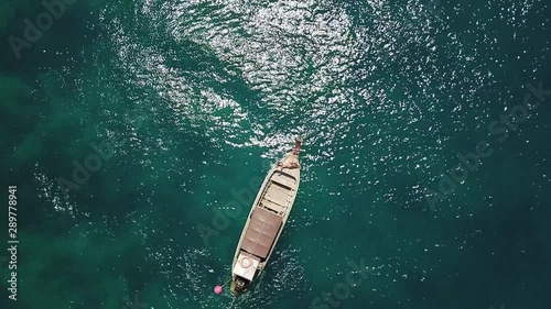 A woman laying on the bow of a longtail boat in Thailand. Boat anchored in Nui Bay, one of the most beautiful places on Phi Phi and Southeast Asia.