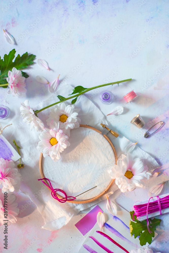Embroidery frame flat lay with flowers. Pink, white and purple pastel tones, copy space Embroidery frame flat lay with flowers. Pink, white and purple pastel tones, copy space