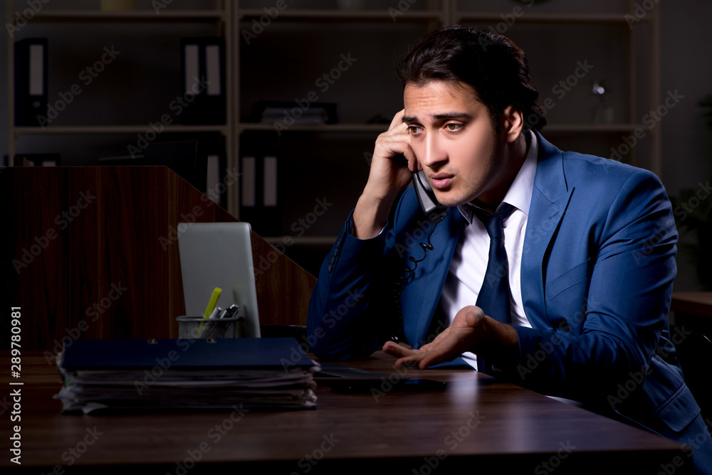 Young male employee working night in the office Young male employee working night in the office