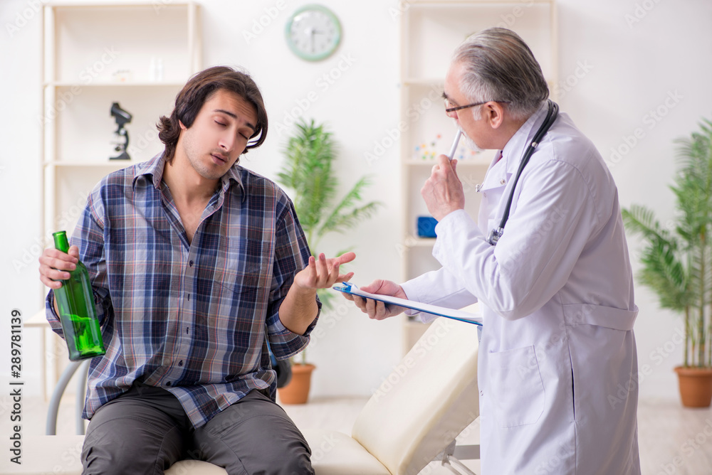 Fototapeta premium Young male alcoholic visiting old doctor