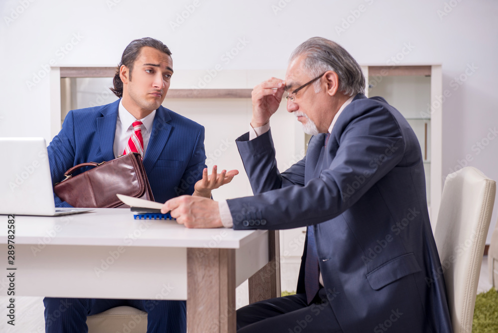 Two businessman discussing business in office Two businessman discussing business in office