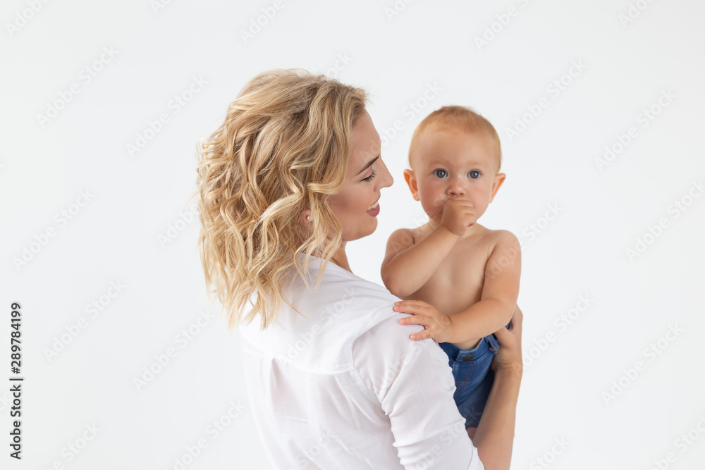 Single parent, motherhood and babyhood concept - Mother holding sweet baby girl on white background Single parent, motherhood and babyhood concept - Mother holding sweet baby girl on white background