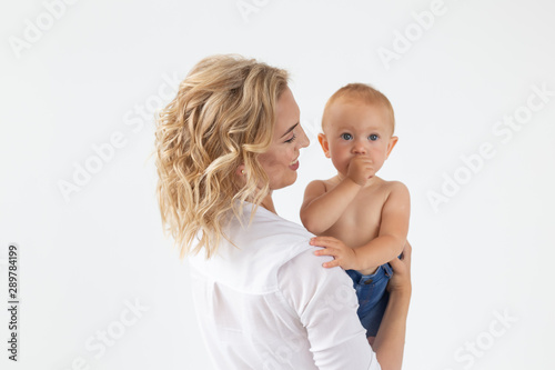 Single parent, motherhood and babyhood concept - Mother holding sweet baby girl on white background
