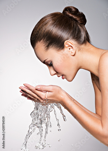 Caucasian woman washing face with water photo