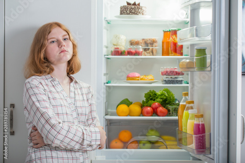 teenager girl at fridge with food