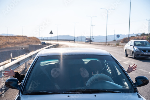 Happy arabic waving of happiness while driving a car © Diya