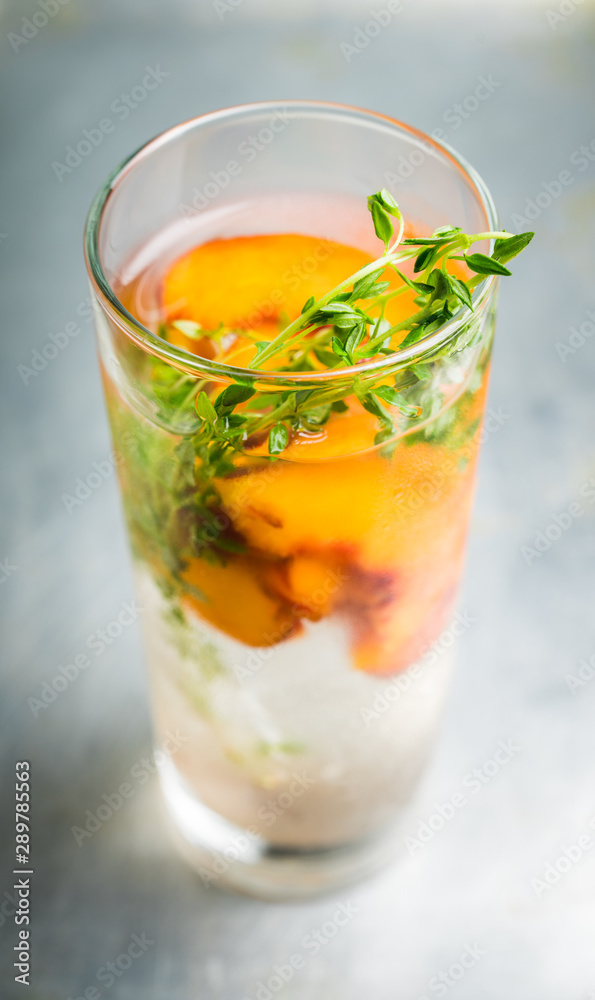 Gin based cocktail with peaches and thyme. Selective focus. Shallow depth of field. Gin based cocktail with peaches and thyme. Selective focus. Shallow depth of field.