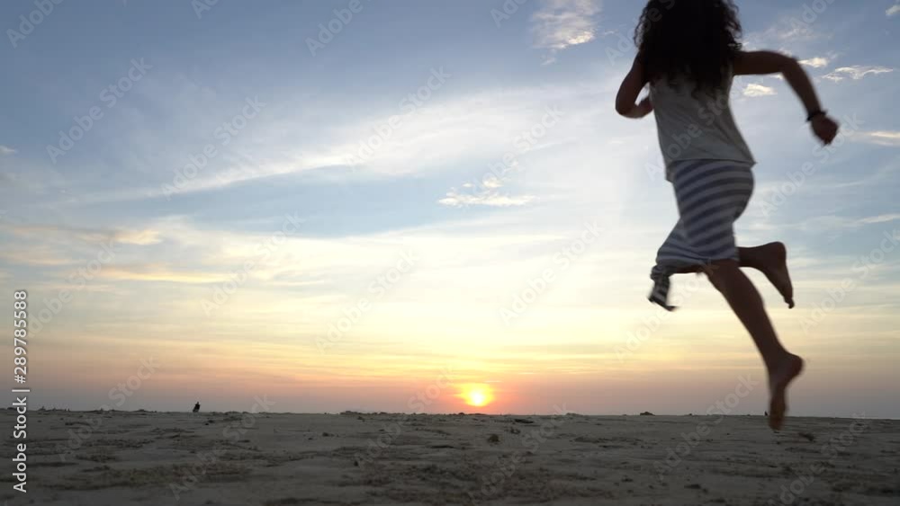Young beauty girl dancing at tropical sand beach near sea water at paradise island at sunset. Summer concept. Holiday travel. Island Koh Phangan, Thailand Young beauty girl dancing at tropical sand beach near sea water at paradise island at sunset. Summer concept. Holiday travel. Island Koh Phangan, Thailand