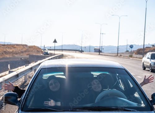 Happy arabic waving of happiness while driving a car © Diya