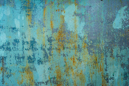 The texture of the old metal surface painted in blue-green color with large stains of rust