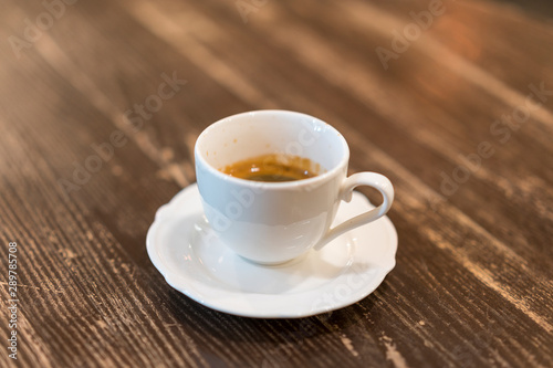 Cup of coffee with foam on wooden table, top view. A cup of coffee on wooden background