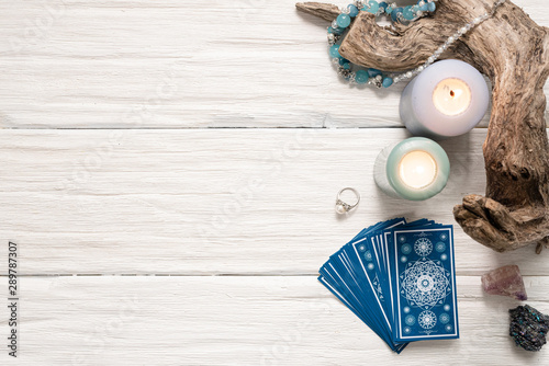 Blue tarot cards on white wooden table background.