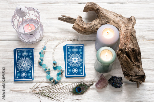 Blue tarot cards on white wooden table background.