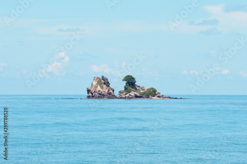 Beautiful small island in tropical blue calm sea in the morning with blue sky background for summer holidays. Travel, nature and inspirational concept