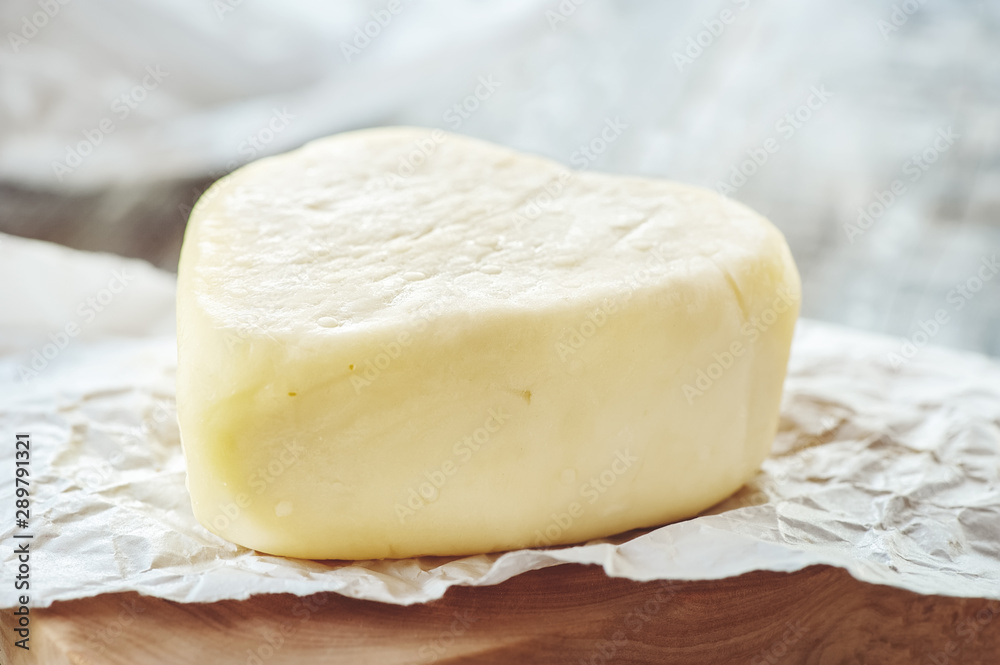 Suluguni cheese is a traditional cheese of the Caucasus. A piece of cheese in the shape of a heart. Suluguni is home-made