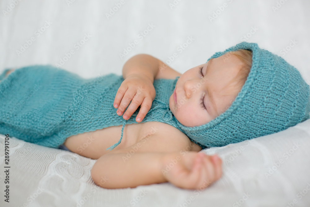 Sweet toddler boy, sleeping with teddy bear toy, cute knitted outfit Sweet toddler boy, sleeping with teddy bear toy, cute knitted outfit