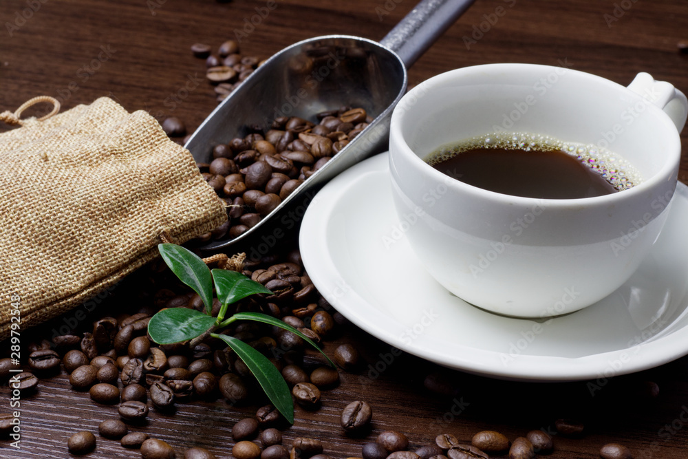 Cup of coffee and coffee beans on a wooden background. Cup of coffee and coffee beans on a wooden background.