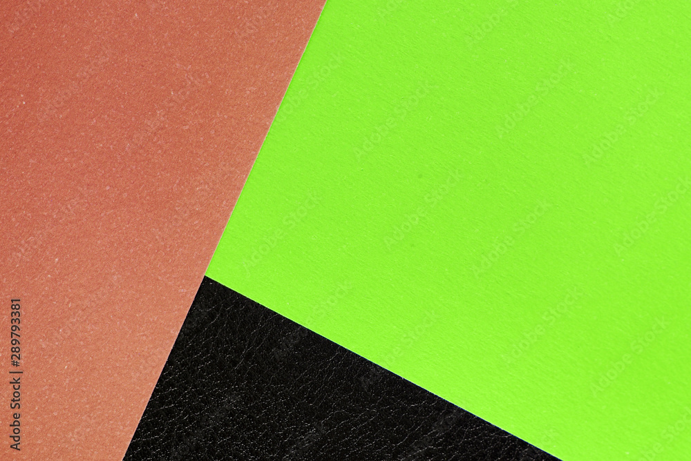 Fototapeta premium Multicolored sheets of paper on a dark leather background close up