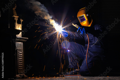 A craftman is welding with workpiece steel.Working person About welder steel Using electric welding machine There are lines of light coming out and safety equipment in factory industry..