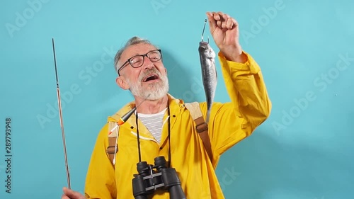 bearded positive man holding caught fish, being happy to catch it. lifestyle, people photo