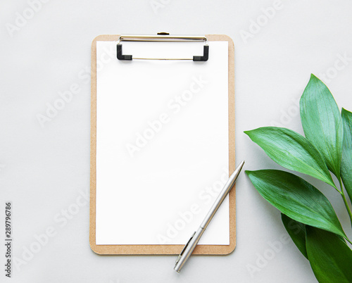 Clipboard and green leaves