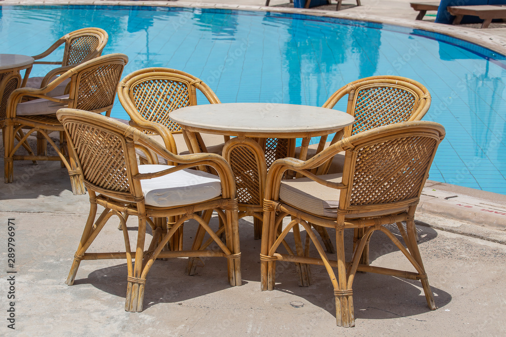 Rattan table and chairs in beach cafe near swimming pool next to the red sea in Sharm el Sheikh, Egypt