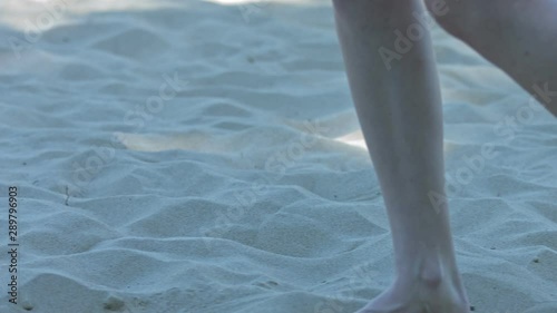 Slow Motion of Beautiful Woman barfoot feet with light skin Walk On The Beach on holiday. Close Up Shot. photo