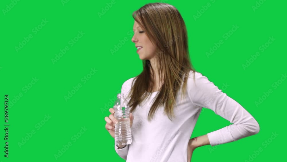 Young Brown Blonde Woman With Water Bottle Looking Interested Smiling And Taking A Sip Young Brown Blonde Woman With Water Bottle Looking Interested Smiling And Taking A Sip