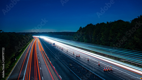 Motorway fast traffic light trails at night photo