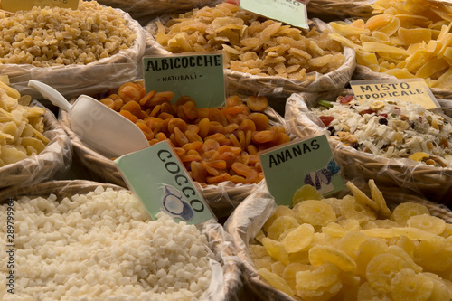 Dried fruit on open street market (souk) in Bergamo Italy. Dried ananas, coconut, apricot and tropical mix in wooden trugs on traditional bazaar. Healthy and naturally dried fruit with vitamins.