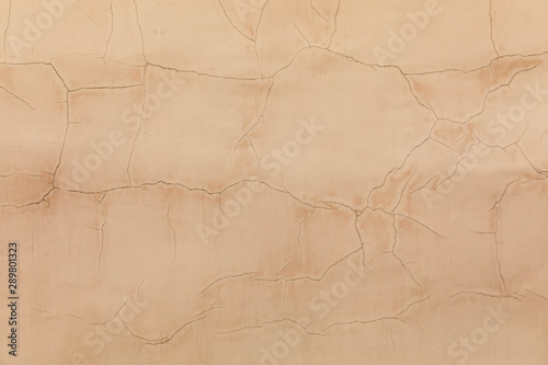 Background of beige plastered wall. Old paint cracked