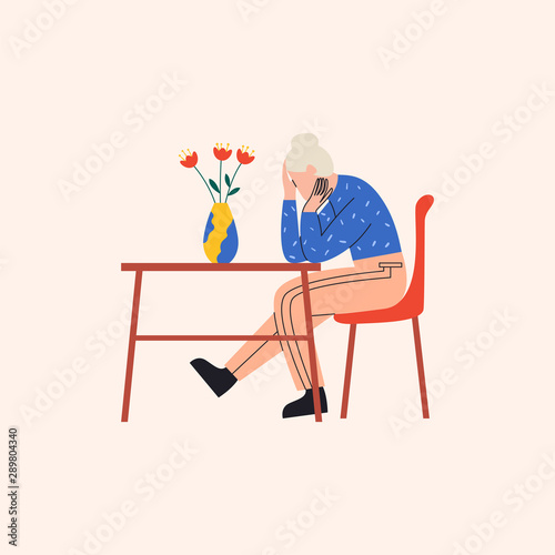 Depressed old woman sitting at the table in miserable pose. There are flowers in vase on the table. Flat vector illustration