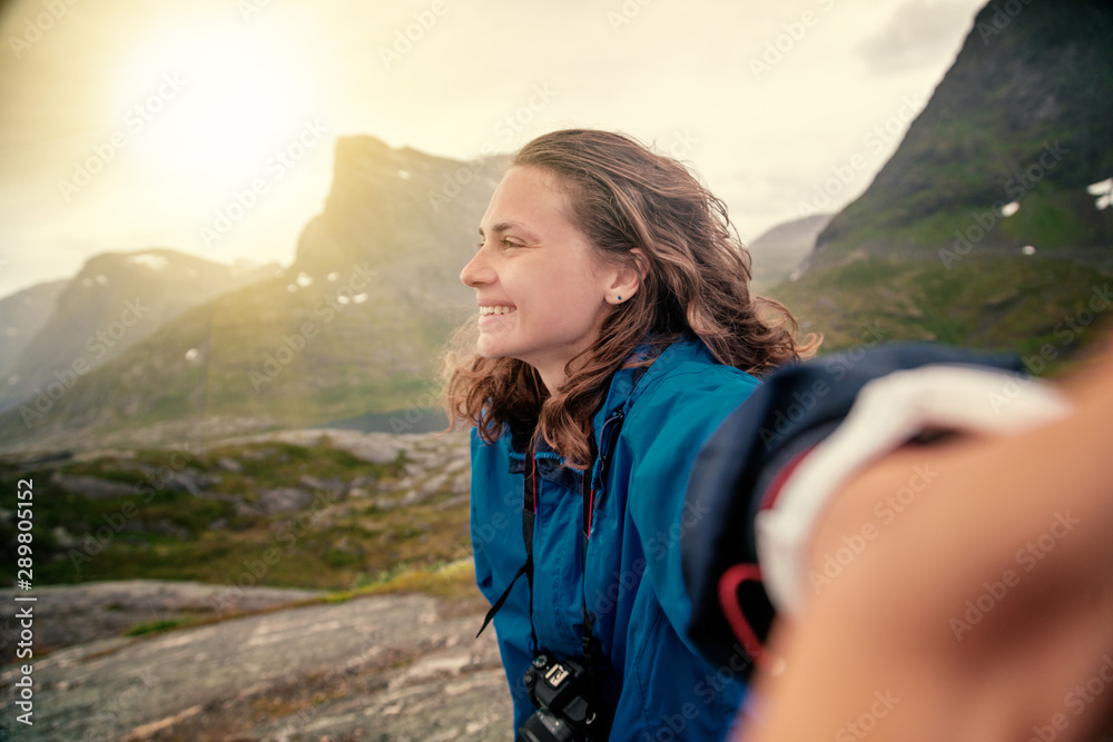 Naklejka premium Young happy young beautiful woman doing selfie on Trolltunga, travel to Norway Scandinavia