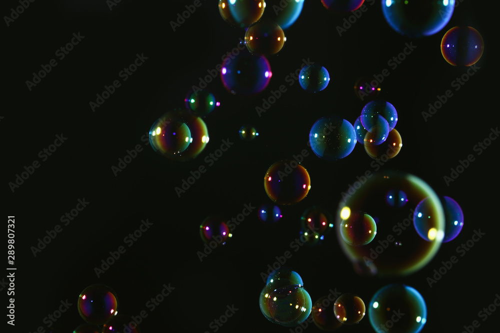 Naklejka premium Beautiful soap bubbles colorful float on dark background