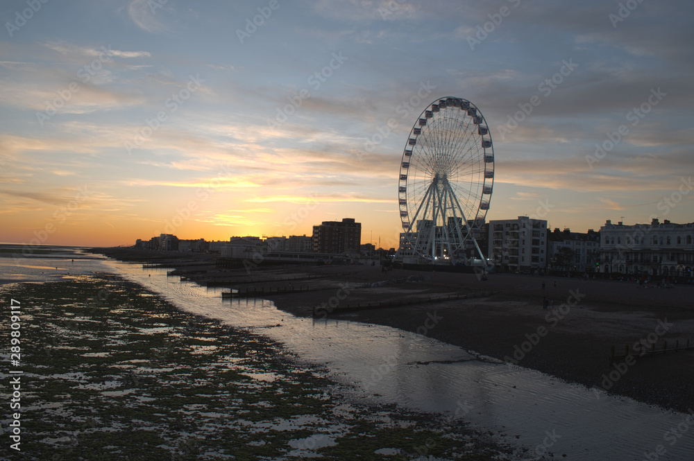 Sunset Worthing England Seafront at low tide with the Observation Wheel in action on beautiful September evening.