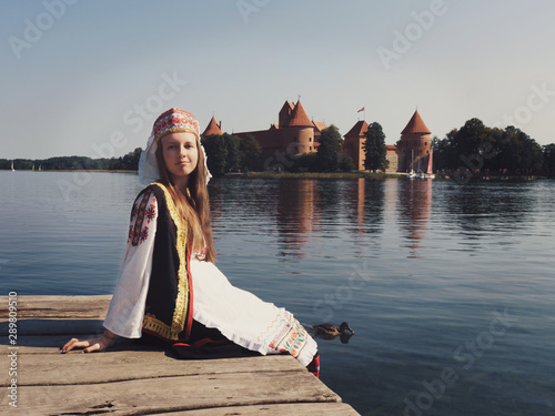 Beautiful girl in national dress in an ancient medieval castle in Trakai in Lithuania. Retro photography. Restoring the atmosphere of the Middle Ages.
