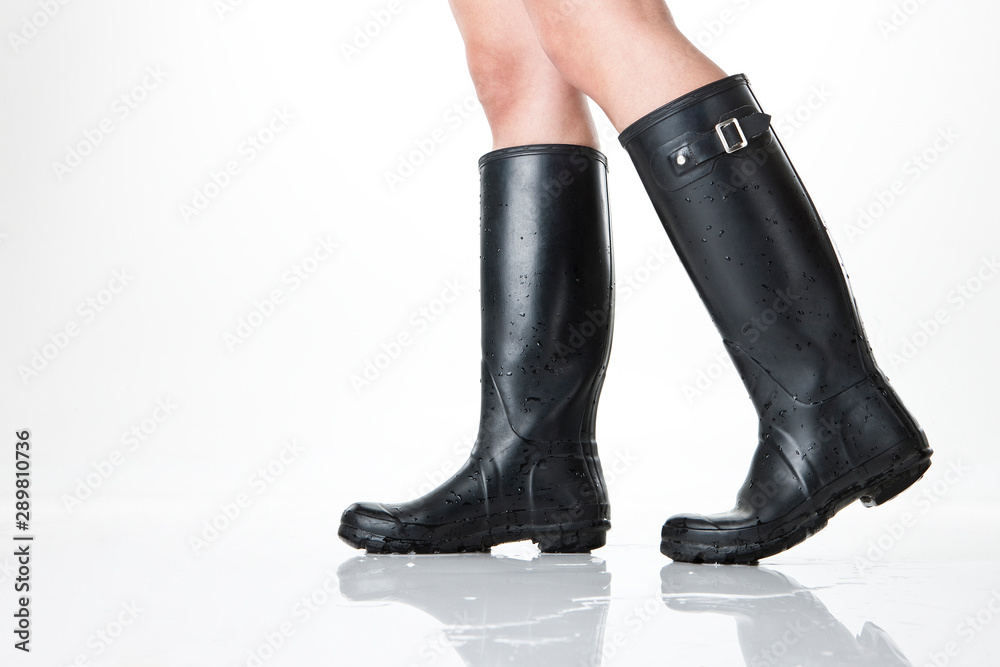 Image of a woman's legs wearing rubber boots. Image of a woman's legs wearing rubber boots.