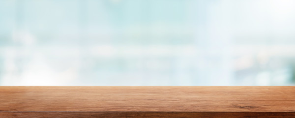 Empty wood table top and blur glass window wall building banner mock up abstract background - can used for display or montage your products.