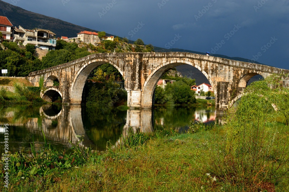 old stone bridge and reflection on river