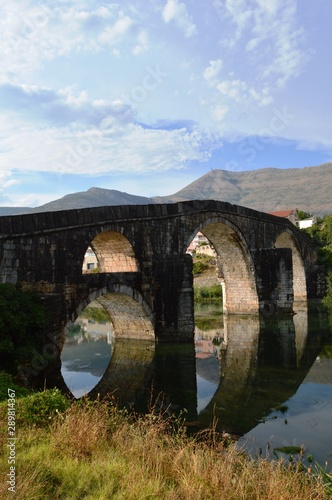 reflection of a stone bridge in a river