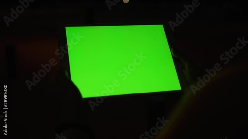 Close up young hands woman uses tablet computer with a horizontal green screen on night street amazing sunset internet map hold pc scroll smart phone social network tourist tracking blank chroma city