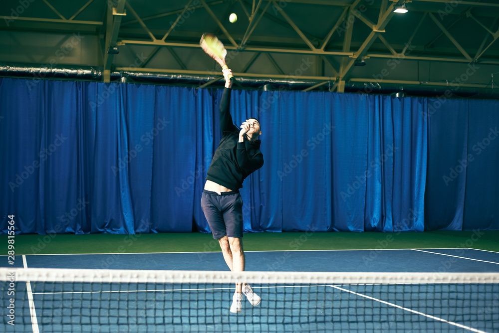 man playing tennis on the court. tournament. athlete jumping with a racket in his hands.