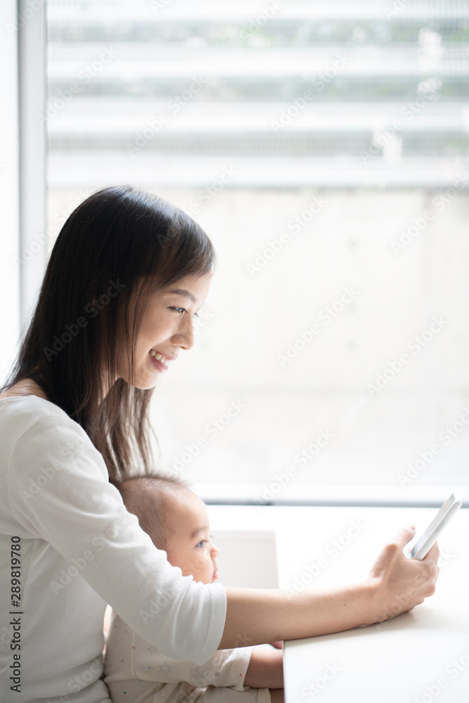 Young mother using smart phone with her baby Young mother using smart phone with her baby