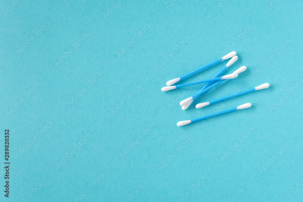 Cotton ear sticks for personal hygiene on blue background. Healthcare tools. Empty space for text. Cotton ear sticks for personal hygiene on blue background. Healthcare tools. Empty space for text.