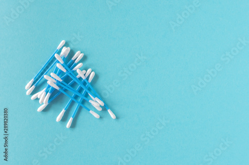 Cotton ear sticks for personal hygiene on blue background. Healthcare tools. Empty space for text.