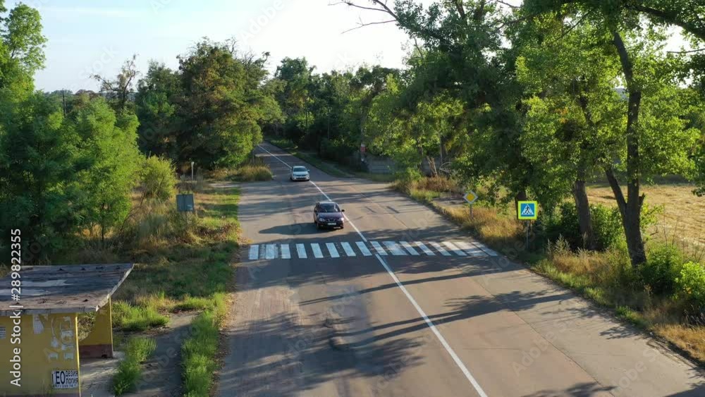 Aerial drone static low shot of cards driving along a road in the Ukrainian countryside Aerial drone static low shot of cards driving along a road in the Ukrainian countryside