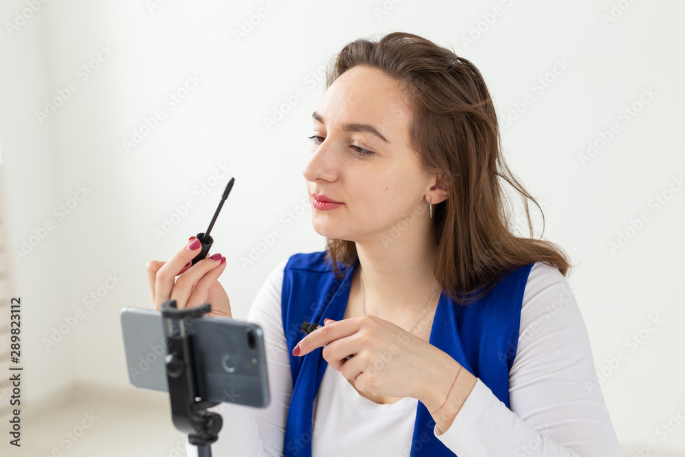 Blogging, broadcast and cosmetics concept - A beauty blogger or video blogger tells and shows her mascara Blogging, broadcast and cosmetics concept - A beauty blogger or video blogger tells and shows her mascara