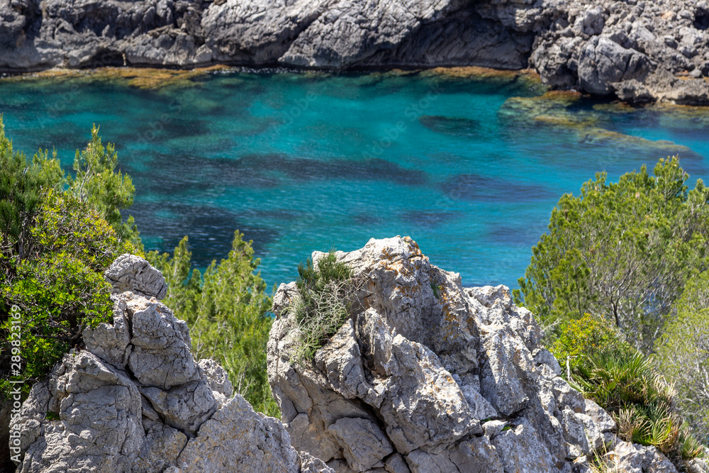 Bucht Ses Caletes auf der Halbinsel La Victoria, Mallorca mit türkisfarbenem Wasser und Felsen im Meer Bucht Ses Caletes auf der Halbinsel La Victoria, Mallorca mit türkisfarbenem Wasser und Felsen im Meer
