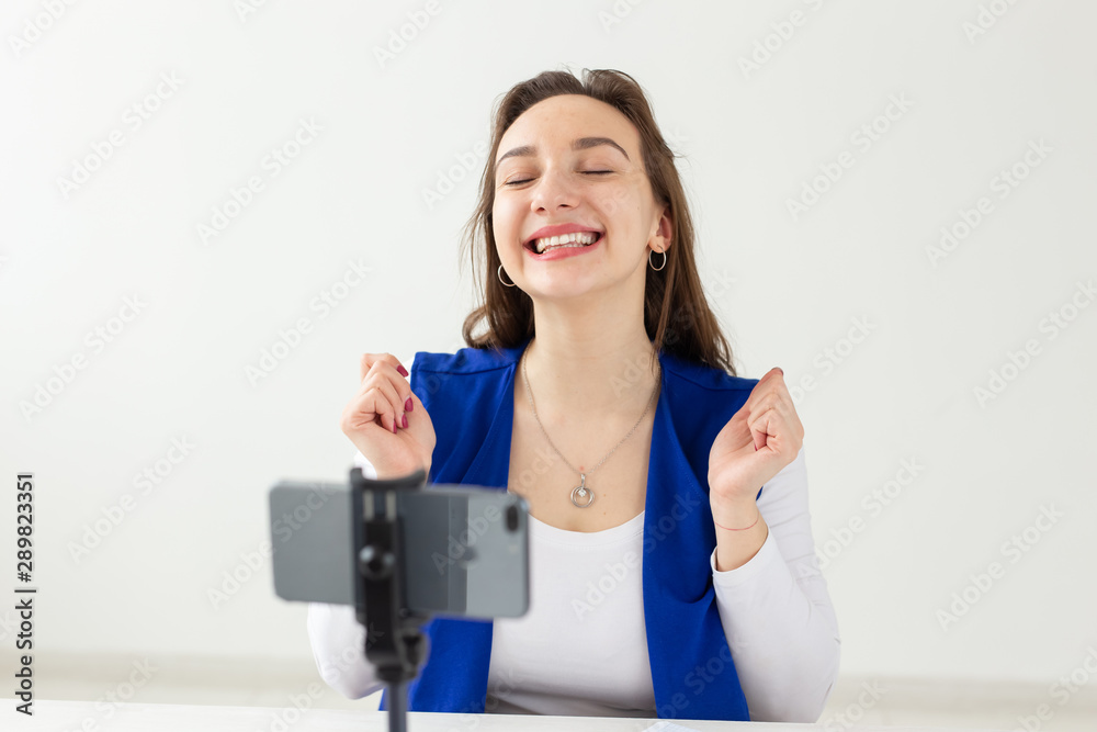 Blogging, broadcast and people concept - woman blogger is talking to the camera for her spectators Blogging, broadcast and people concept - woman blogger is talking to the camera for her spectators
